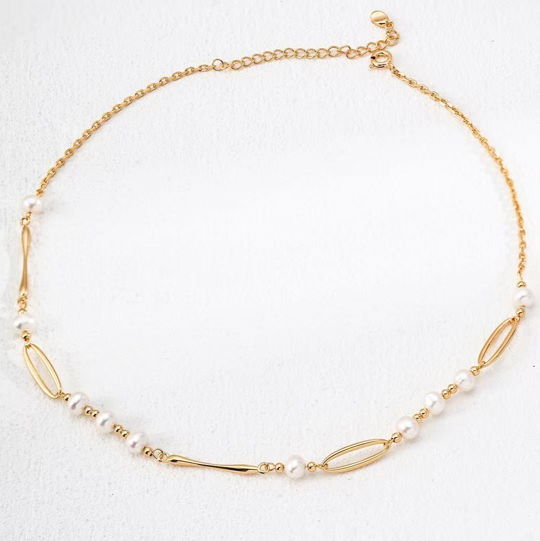 Gold necklace with pearls on a white background