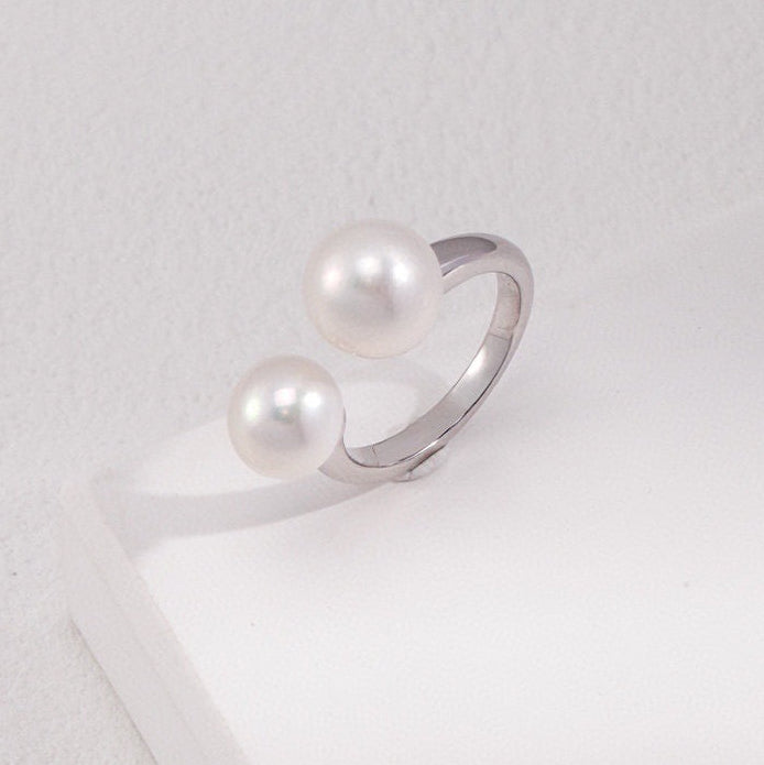 Silver ring with pearls on a white surface