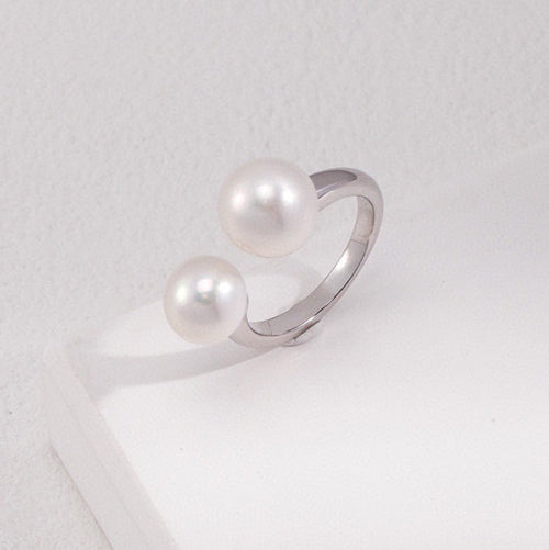 Silver ring with pearls on a white surface